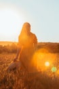 Woman in yellow sundress walking by wheat field Royalty Free Stock Photo