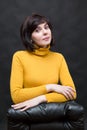 Woman in a yellow sweater, office manager near a leather