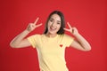 Woman in yellow t-shirt showing number four with her hands on red background Royalty Free Stock Photo