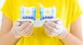 Woman in a yellow t-short holding an ice cream Mcflurry in medical gloves. Delivery McCafe. fast food restaurant
