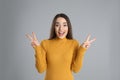 Woman in yellow turtleneck sweater showing number four with her hands on grey background Royalty Free Stock Photo