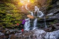 Woman with yellow umbrella near forest waterfall Royalty Free Stock Photo