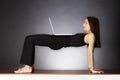 Woman in yoga bridge pose with laptop. Royalty Free Stock Photo