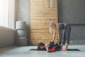 Woman with yoga instructor in class, asana cobbler pose
