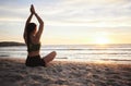 Woman, yoga and meditation on the beach in sunset for spiritual wellness or zen workout outdoors. Female yogi relaxing