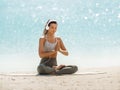 Woman in Yoga Meditation Pose with Headphones on the Beach Royalty Free Stock Photo