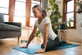 Woman, yoga and pigeon pose stretching in house or home living room for relax exercise, training and workout in Germany