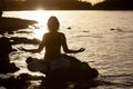 Woman yoga and lotus silhouette pose meditation and relax in the mountan lake. Healthy and Zen Concept Close up