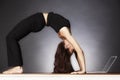 Woman in yoga wheel pose with laptop.