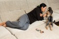 Woman - yorkshire terrier owner laying on the sofa with two dog Royalty Free Stock Photo