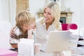 Woman and young boy in home office with laptop Royalty Free Stock Photo