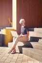 Woman young entrepreneur with short hair working on laptop, screen space for design layout. Sitting outside in cafe, feel happy. Royalty Free Stock Photo