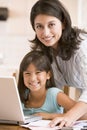 Woman and young girl in kitchen with laptop Royalty Free Stock Photo