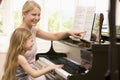Woman and young girl playing piano and smiling Royalty Free Stock Photo
