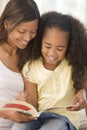 Woman and young girl sitting in living room Royalty Free Stock Photo