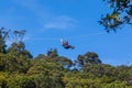 Woman zip lining thru the forest