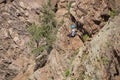 Woman ziplining down a cliff in the Rocky Mountains of Colorado