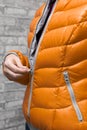 woman zips up her warm colored jacket