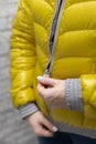 woman zips up her warm colored jacket
