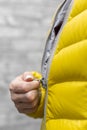 a woman zips up the zipper on her colored jacket with her hand