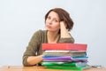 Womanl office staff thoughtfully leaning on a stack of folders Royalty Free Stock Photo