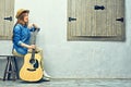 Womann sitting on bench with guitar. Royalty Free Stock Photo