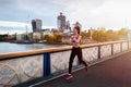 A womanruns in front of the cityscape of London, United Kingdom