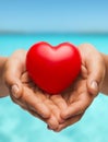 Womans cupped hands showing red heart