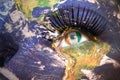 Womans face with planet Earth texture and ivorian flag inside the eye.