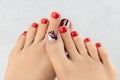 Womans feet and hands on gray background. Beautiful summer red nail design Royalty Free Stock Photo