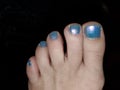 Womans feet painted with blue nail polish