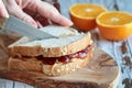 Womans Hand Cutting a Peanut Butter and Strawberry Jelly Sandwich
