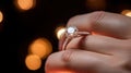 a womans hand holding a diamond ring on her finger Royalty Free Stock Photo