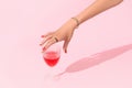 Womans hand holding glass on pink background. Manicure design trends Royalty Free Stock Photo