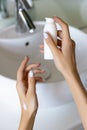 Womans hand holding lotion or cream in the bathroom Royalty Free Stock Photo