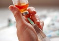 Womans hand nurse health worker holds syringe and dials medicine from bottle on white background