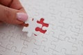 Womans hand placing last piece of puzzle on table closeup Royalty Free Stock Photo