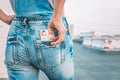 A womans hand takes out euro bills from the back pocket of her jeans. The concept of finance, savings, financial expenses. Close- Royalty Free Stock Photo