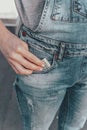 A womans hand takes out US dollar bills from her jeans pocket. The concept of finance, savings, financial expenses. Close-up. Royalty Free Stock Photo