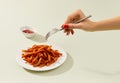 Womans hand takes sweet potato fries on green table. Vegan alternative food recipe.