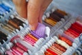 Womans hand taking a bobbin with purple embroidery thread from a sorting box Royalty Free Stock Photo