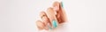 Womans hand with trendy turquoise manicure with copy space