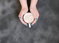 Womans hands with blue manicure holding a cup of hot coffee on black background Royalty Free Stock Photo