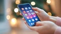 Womans Hands Browsing Social Media Apps on Smartphone with Festive Bokeh Background Royalty Free Stock Photo