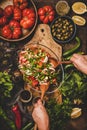 Womans hands cooking Turkish Chopard Salad with vegetables, herbs, spices