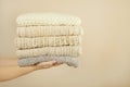 Stack of warm pastel sweaters, holding in womans hands Royalty Free Stock Photo