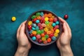 Womans Hands Holding Bowl Of Assorted Candies On Blue Background, Top View. Generative AI