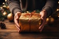 Womans hands holding a box with Christmas present. Wrapping Christmas gifts on Christmas eve. Using craft paper for packaging.