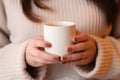 Womans hands holding a plan white blank mug cup, beige neutral rustric cottagecore Royalty Free Stock Photo