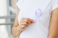 Womans hands holding purple domestic violence awareness ribbon Royalty Free Stock Photo